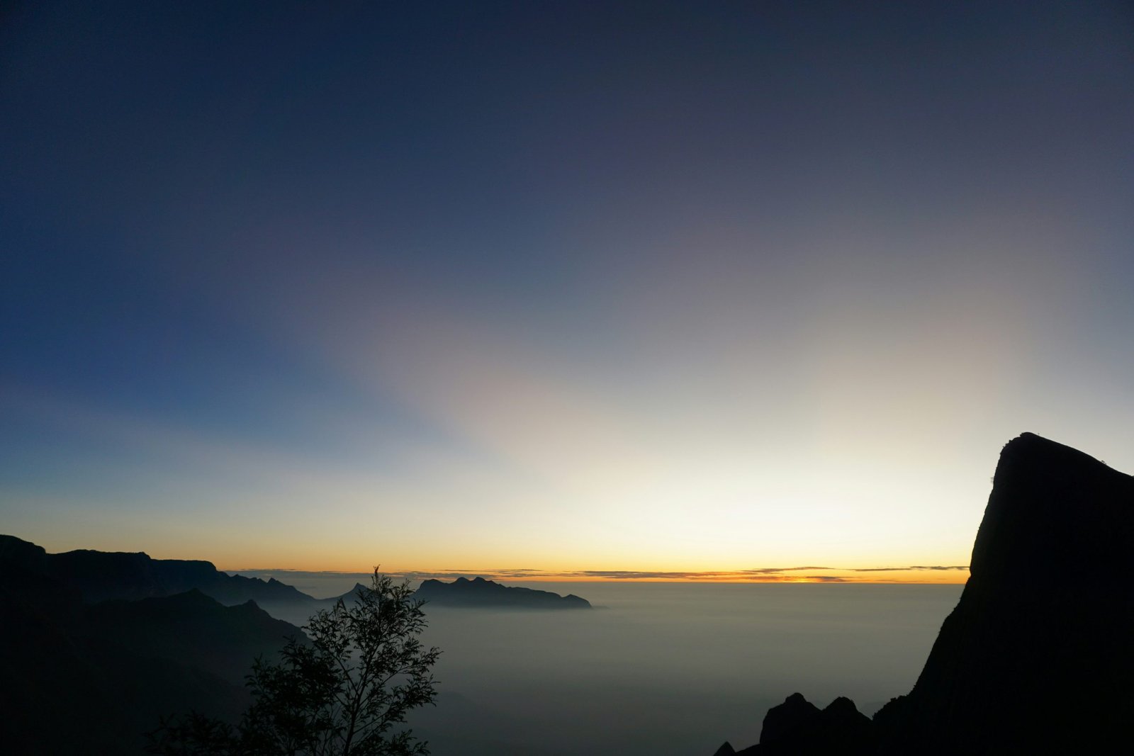 the sun is setting over a mountain range